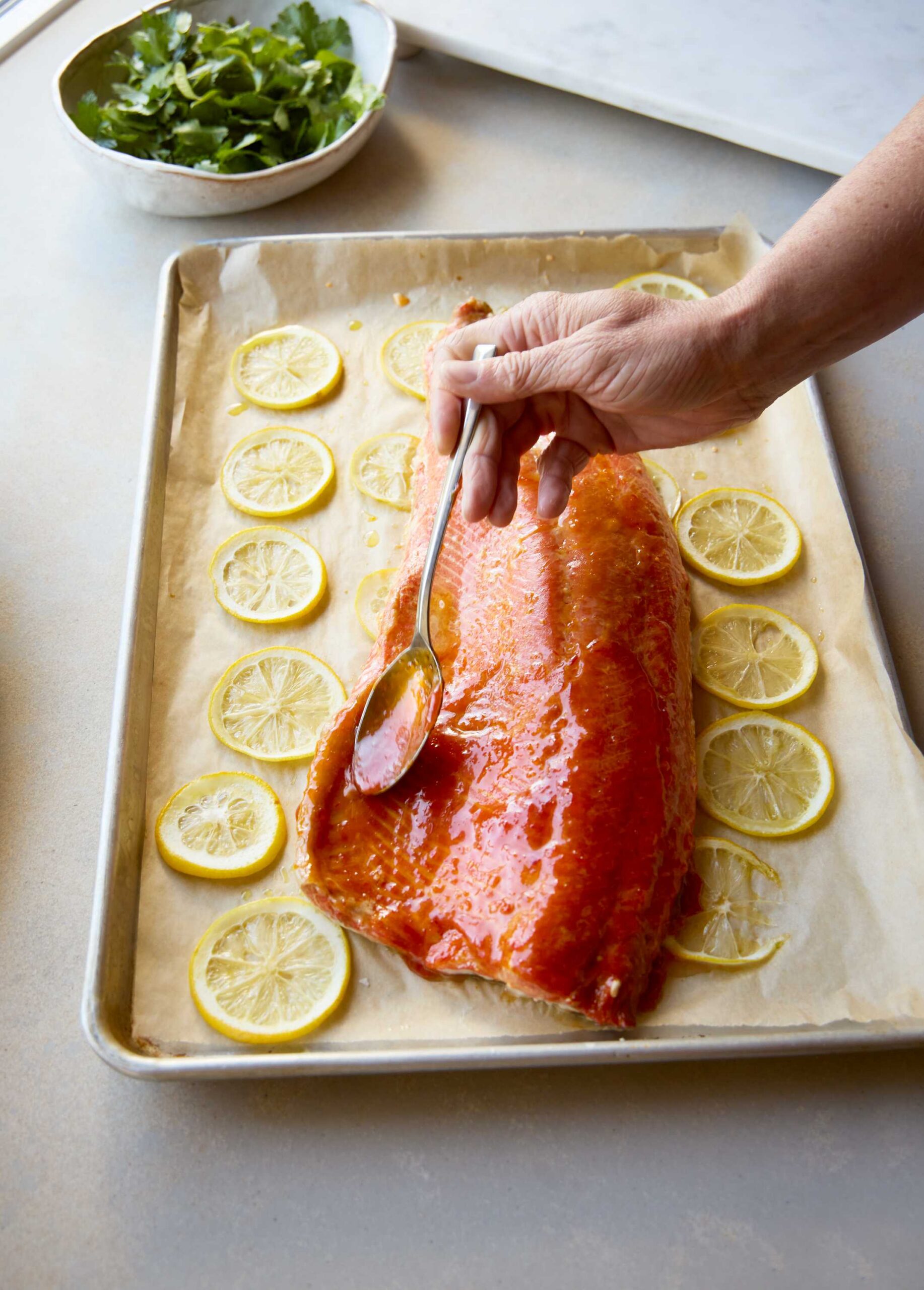 Harissa citrus glaze bring brushed onto a wild sockeye side
